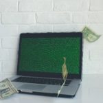The picture shows a computer with money coming out of it, representing financial fraud.