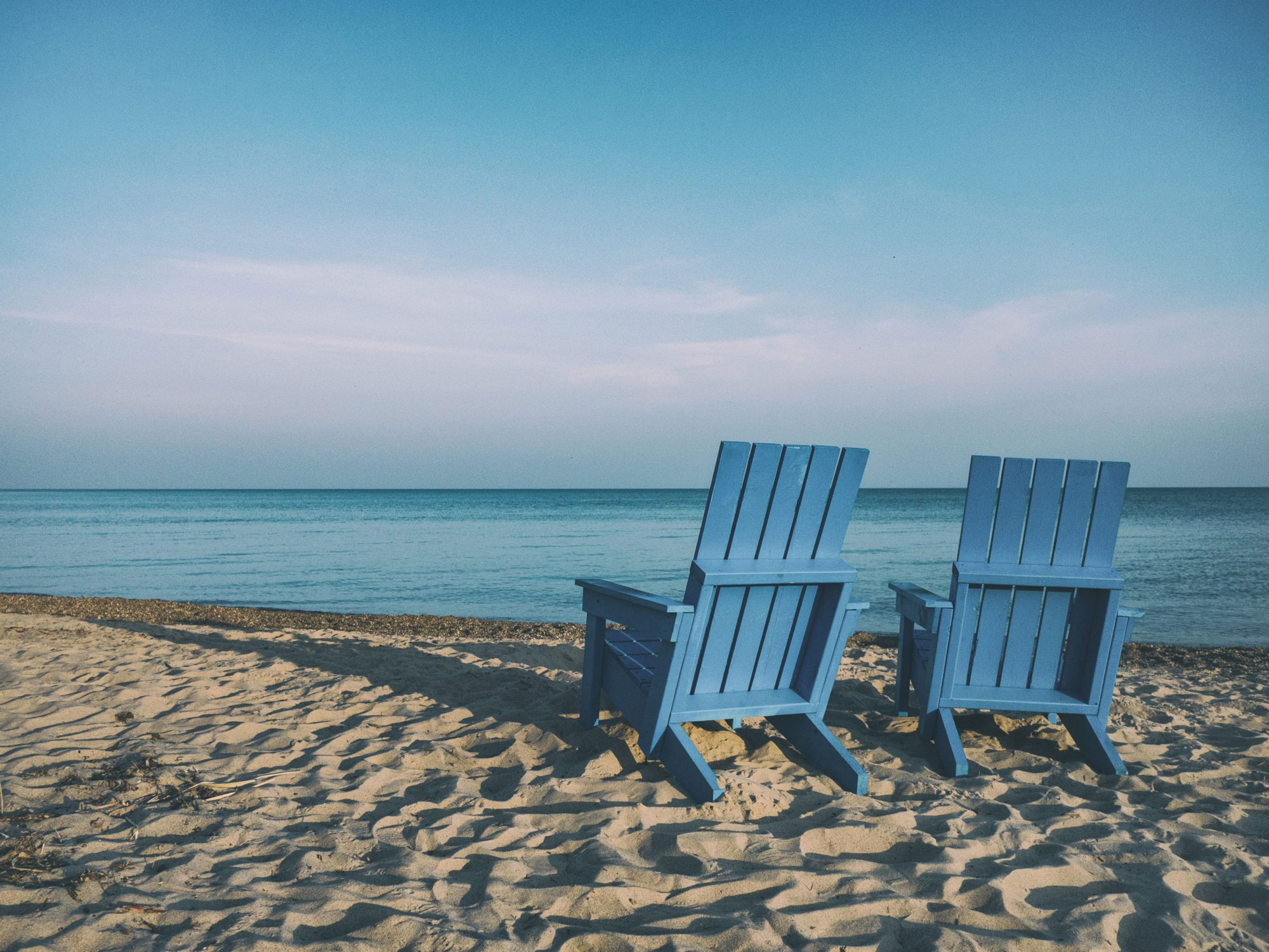The picture shows to chairs on a beach, representing retirement.