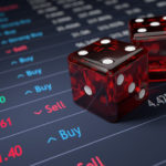 The picture shows dice on a stock report to signify risk and relate to a backup budget.