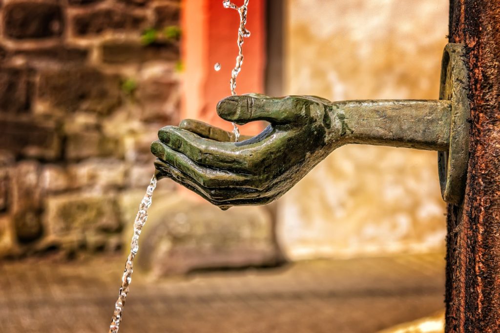 The picture is of a fountain with outstretched hands to represent charitable giving.