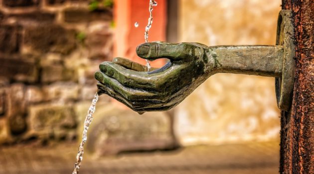 The picture is of a fountain with outstretched hands to represent charitable giving.