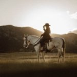 The picture shows a woman in western attire on a horse to represent the new trader in town.