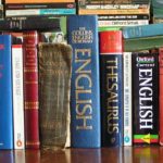 The picture shows a shelf full of dictionaries to represent financial terminology.