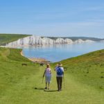 The picture shows an older couple hiking on a beautiful day to represent retirement and the SECURE Act.