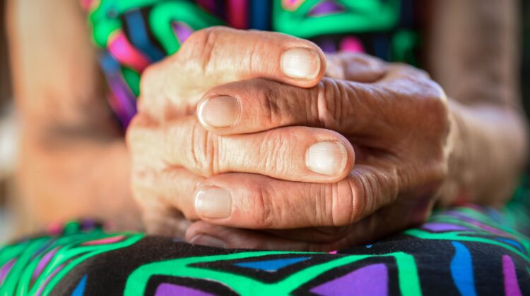 The picture shows an older person's hands to represent the difficult decisions that go into deciding whether to live in a CCRC.