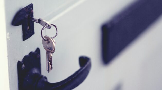 The picture is of a key in the lock of a front door because the article debates buying or renting a house.
