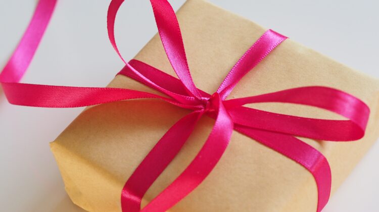 The picture shows a gift wrapped with a ribbon to represent charitable giving.