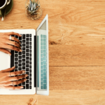 The picture shows a person typing on a keyboard to represent writing articles.