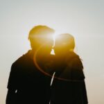 The picture is a silhouette of a couple in the sun to represent the title, Managing Money as a Couple: Thinking About Marriage.