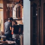 The image shows a young couple preparing breakfast together to represent early marriage.