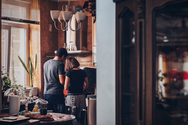 The image shows a young couple preparing breakfast together to represent early marriage.