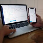 The picture shows someone looking at their computer to check investment returns.