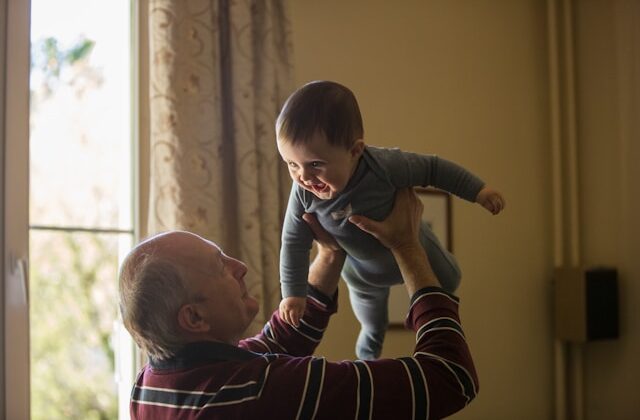 The picture is of a grandfather playing with his baby grandchild to represent the Social Security Family Benefit.