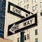 The picture shows two one-way signs to symbolize the fact that there are different ways to look at investing.