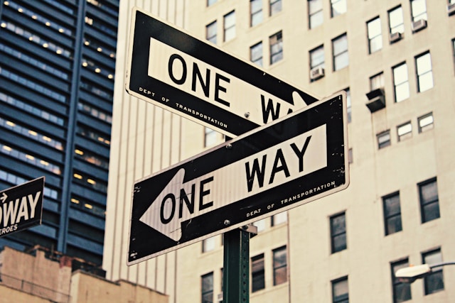 The picture shows two one-way signs to symbolize the fact that there are different ways to look at investing.